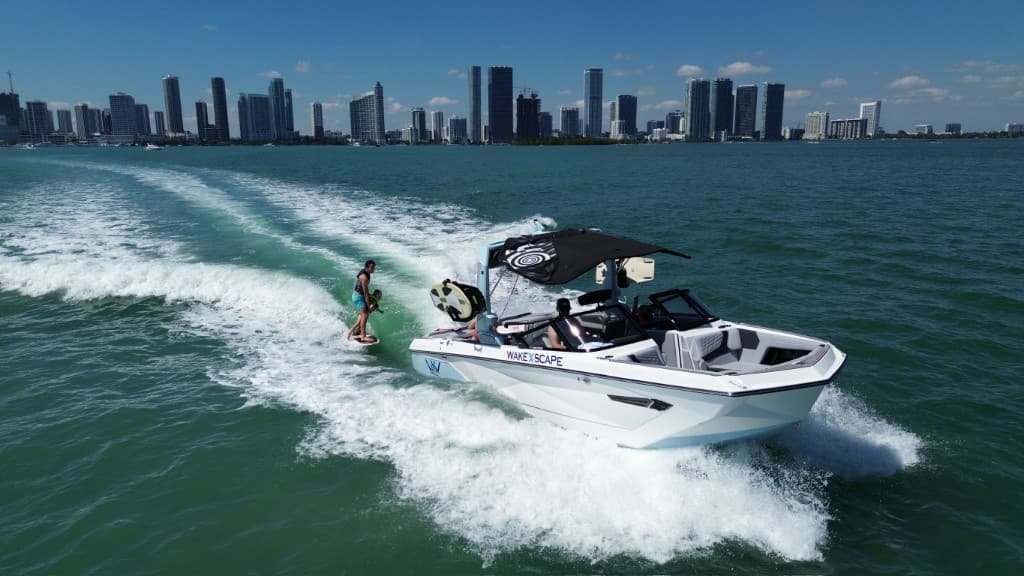 WakeXscape boat pulling a wakesurfer across Biscayne Bay with the Miami skyline in the background